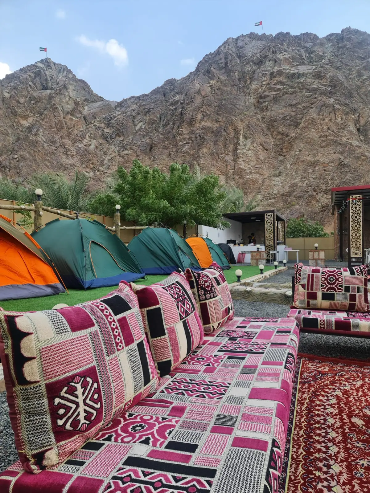 Outdoor majlis seating with the mountains behind