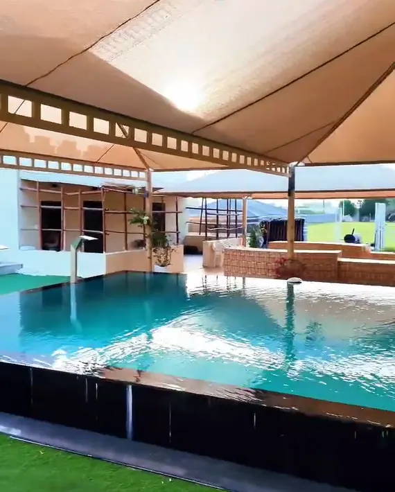 Large shaded swimming pool at Fam House