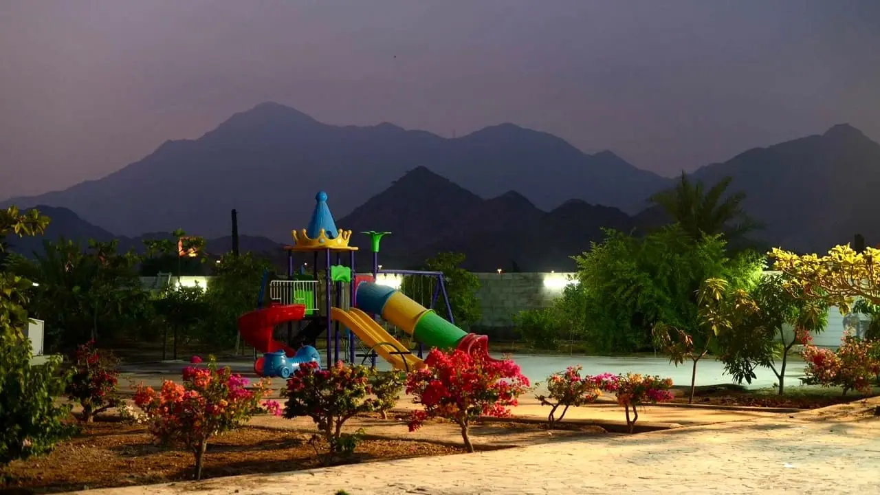 Paradise Farm play area at dusk, with the mountains behind